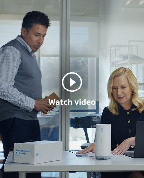 in the Wake Up with Craig office, Oscar stands beside Angela, who's seated at a desk. The two of them are looking at an AT&T Internet Air for Business gateway.