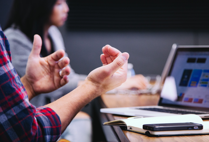 Man working on a laptop and explaining to audience.